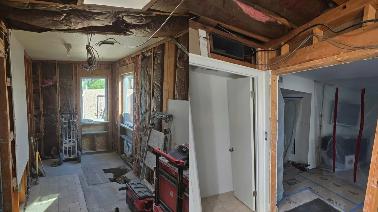 A house interior stripped to the studs, with open ceilings, exposed framing and work boxes on the floor.