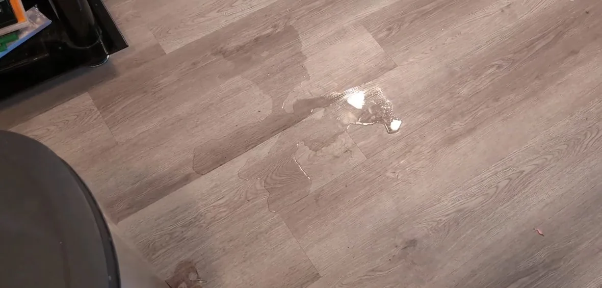 Puddles of water spread across a gray plank floor.